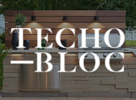 “TECHO-BLOC” sign over a wood-and-stone wall with greenery behind it