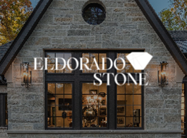Stone storefront with “Eldorado Stone” sign and warm-lit windows at dusk