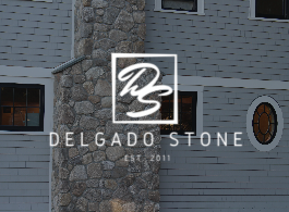 Delgado Stone logo over a gray stone house exterior, with “EST. 2011” text.