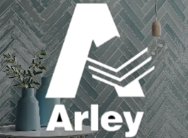Arley logo on a gray tiled wall with a blue vase and plant beside it