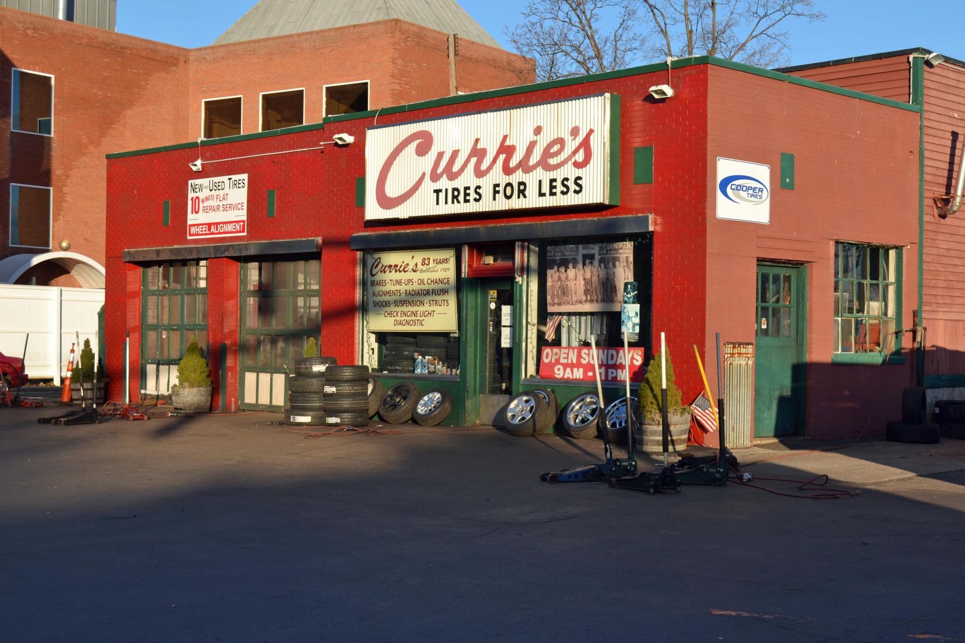 a red building with a sign that says currie 's tires for less