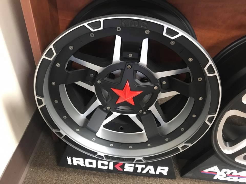 a black and silver rockstar wheel with a red star on it