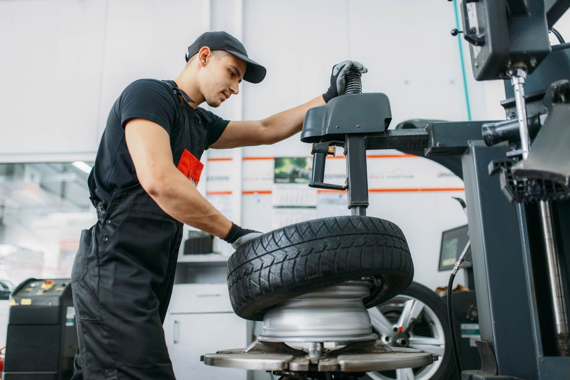 a man is changing a tire on a machine in a garage