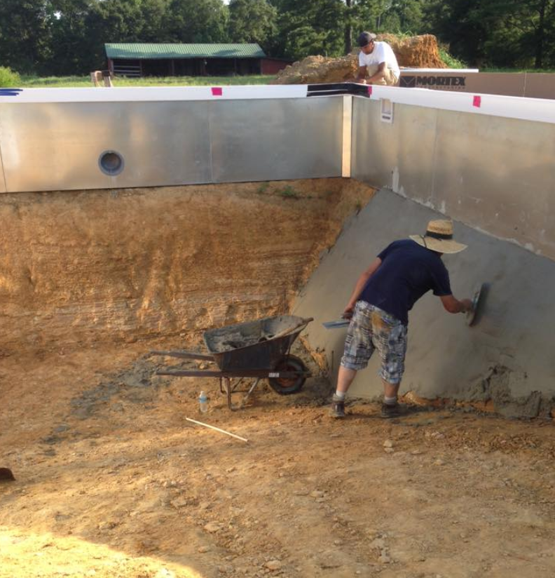 A man wearing a hat is working on a wall