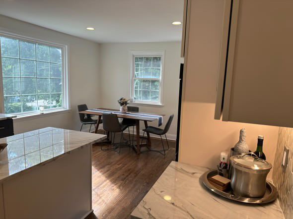 A kitchen with a table and chairs and a pot on the counter.