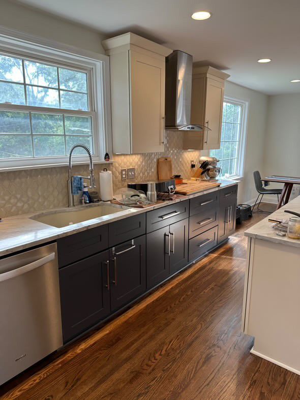 A kitchen with a sink , dishwasher , and stove.
