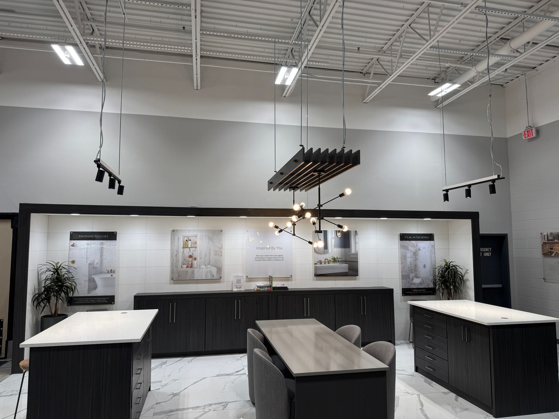 Kitchen display with cabinets, countertops, lighting fixtures, and a table.