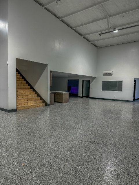 A large empty room with stairs leading up to the second floor.