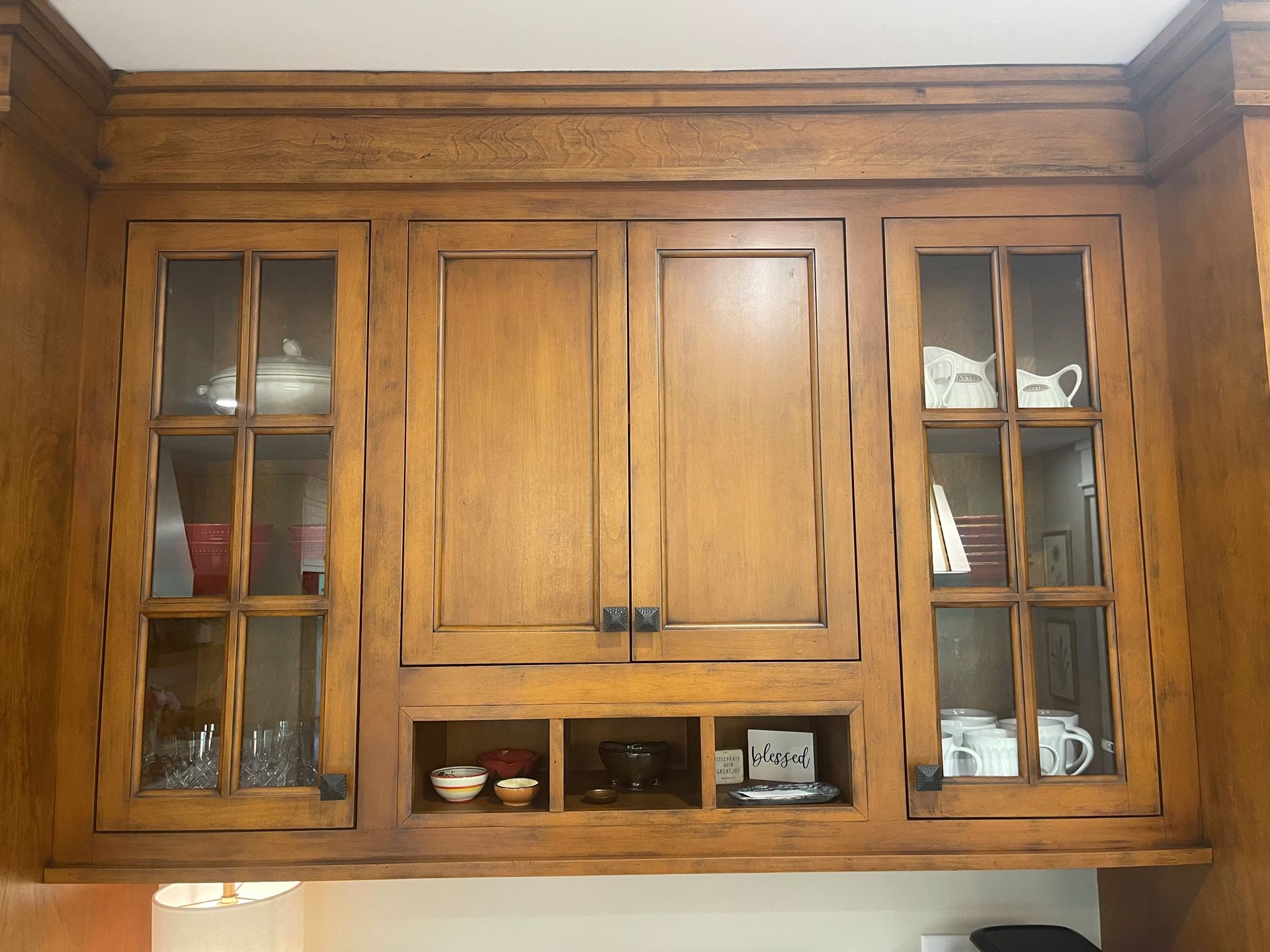 A kitchen with wooden cabinets and glass doors