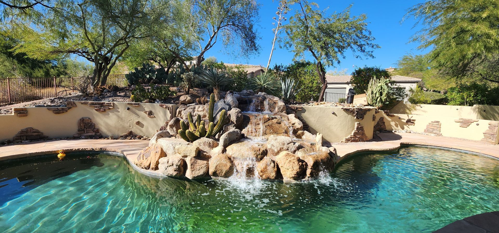 A large swimming pool with a waterfall in the middle of it.