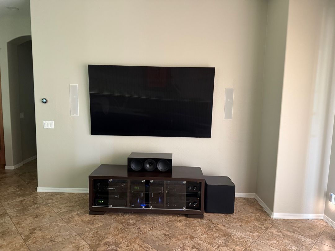 A living room with a flat screen tv mounted on the wall.