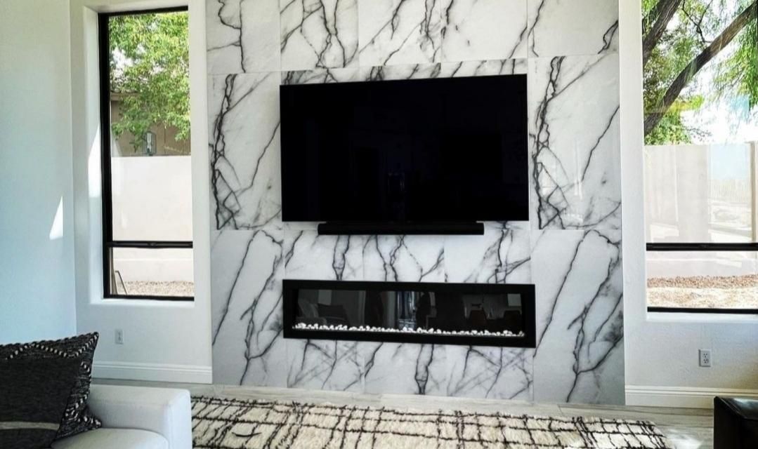 A living room with a fireplace and a flat screen tv on the wall.