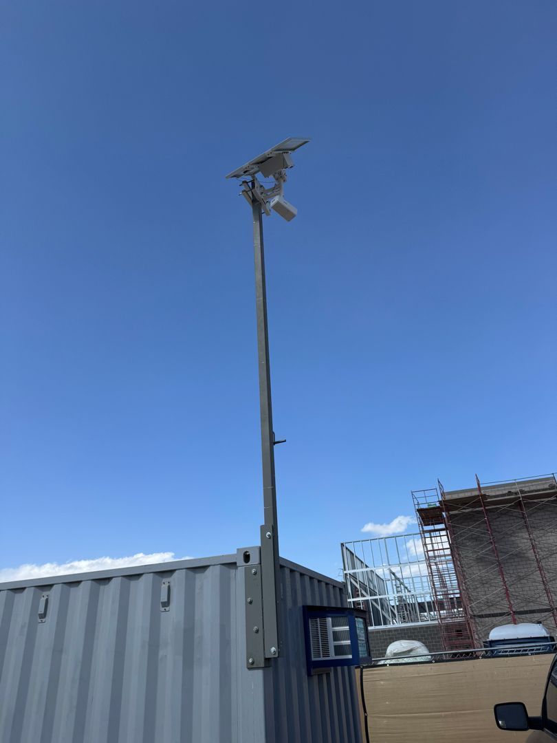 A pole with a camera on it and a blue sky in the background