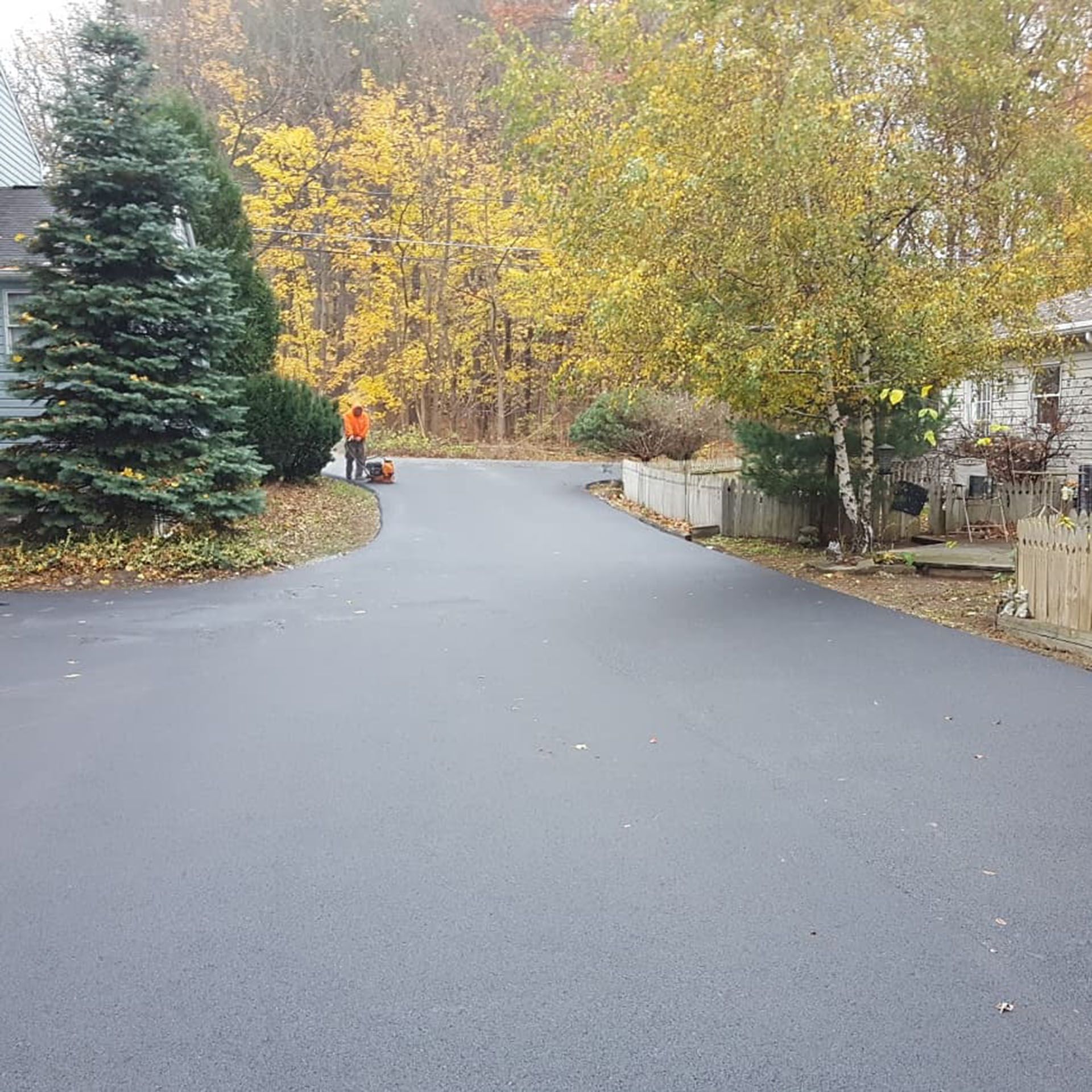 a worker is finishing a driveway paving job