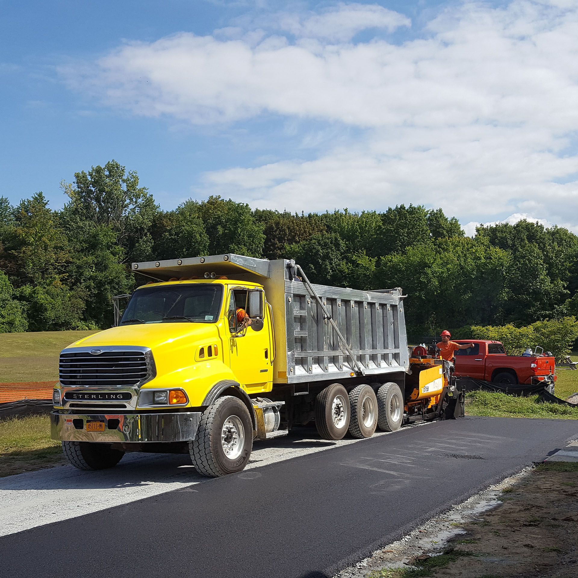 a yellow dump truck - paving job