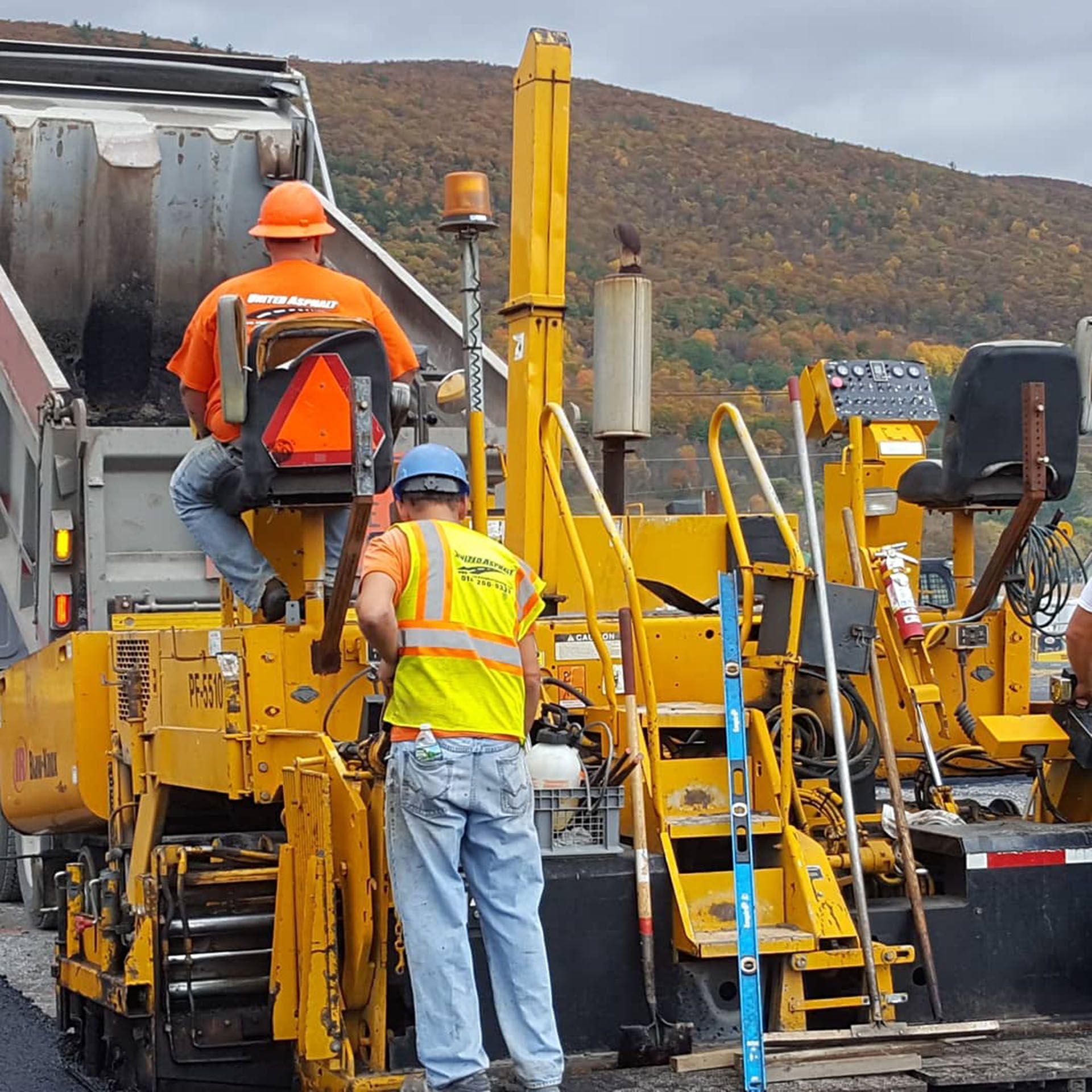 workers operating paving equipment