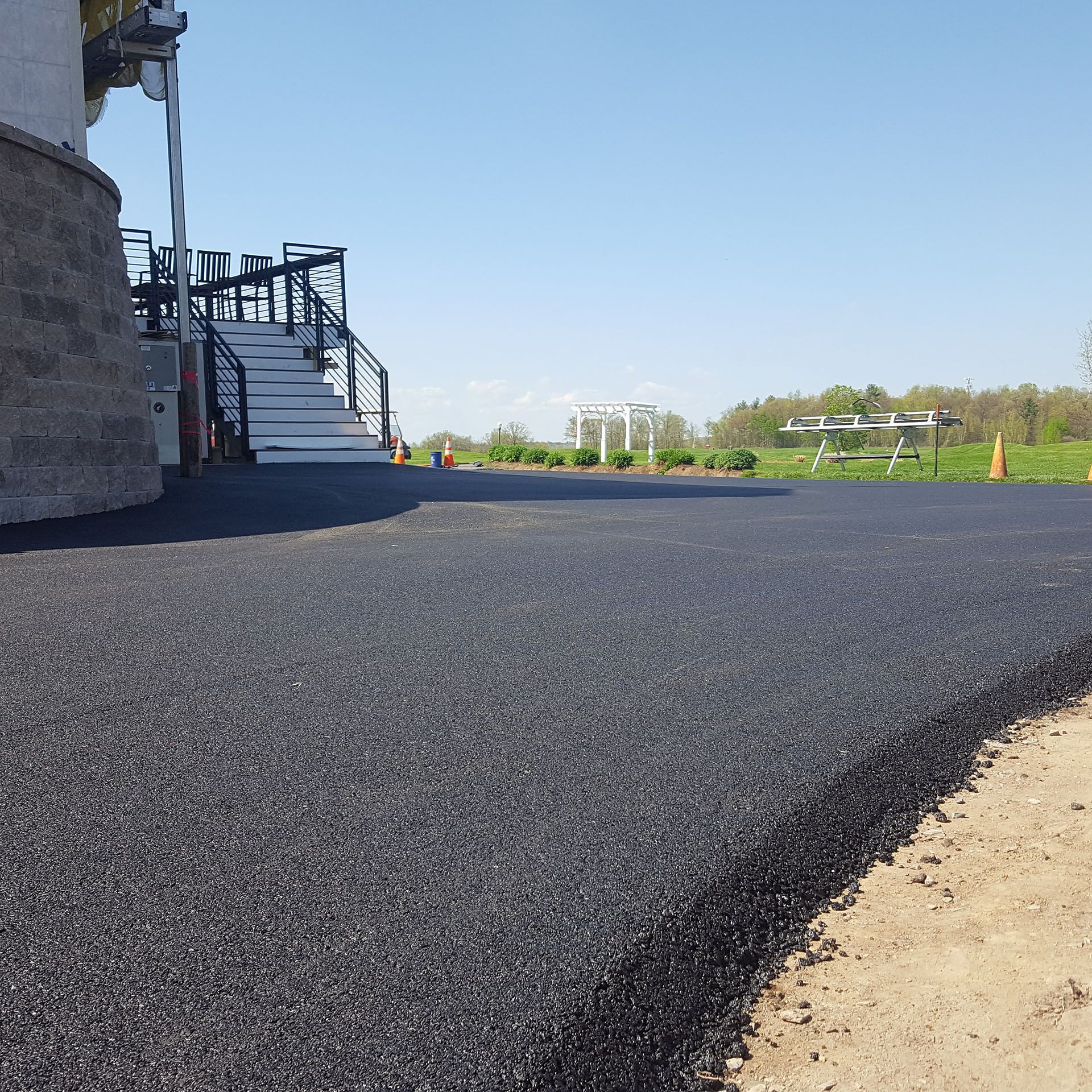 a new black asphalt driveway with stairs in the background