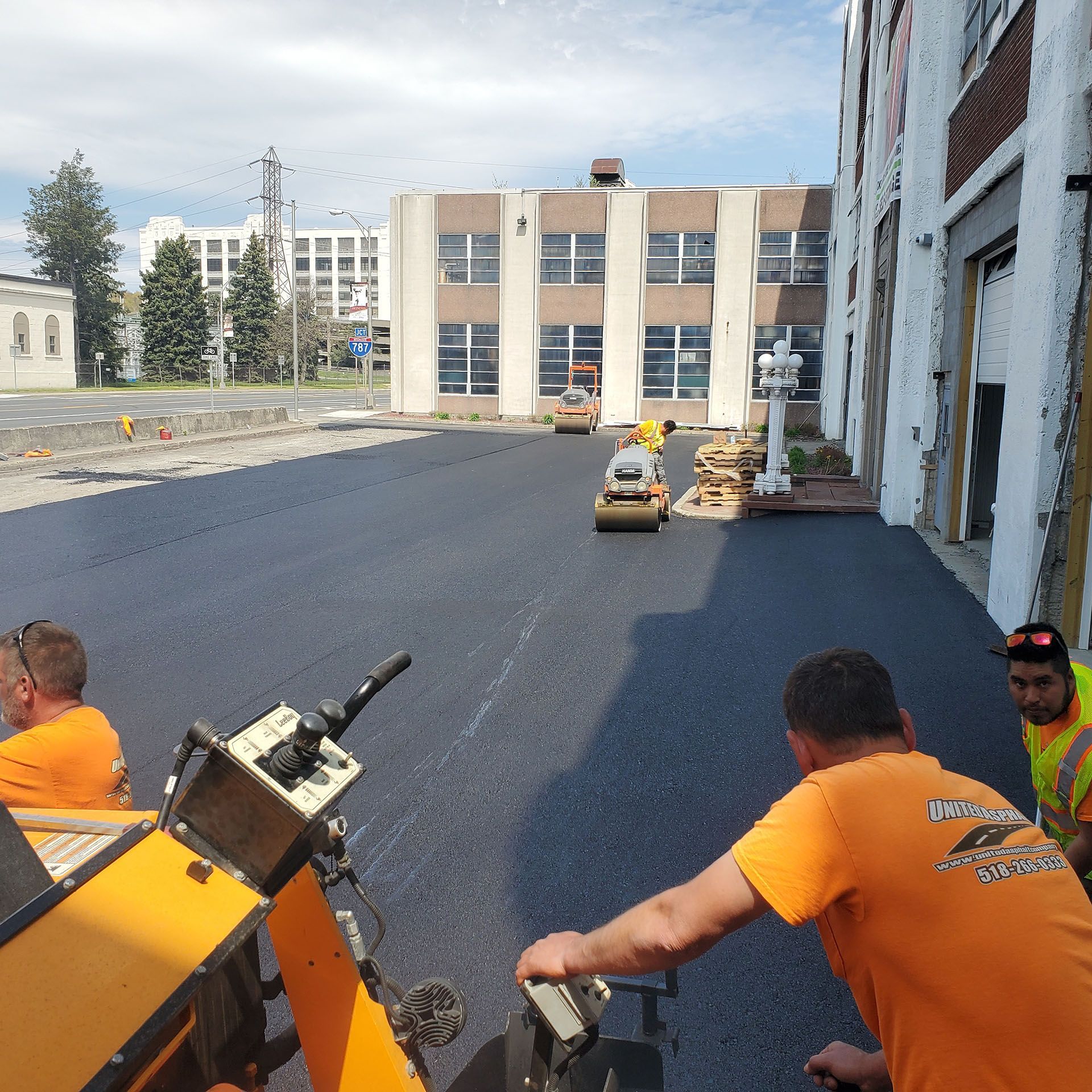 a group of paving workers are working on a road