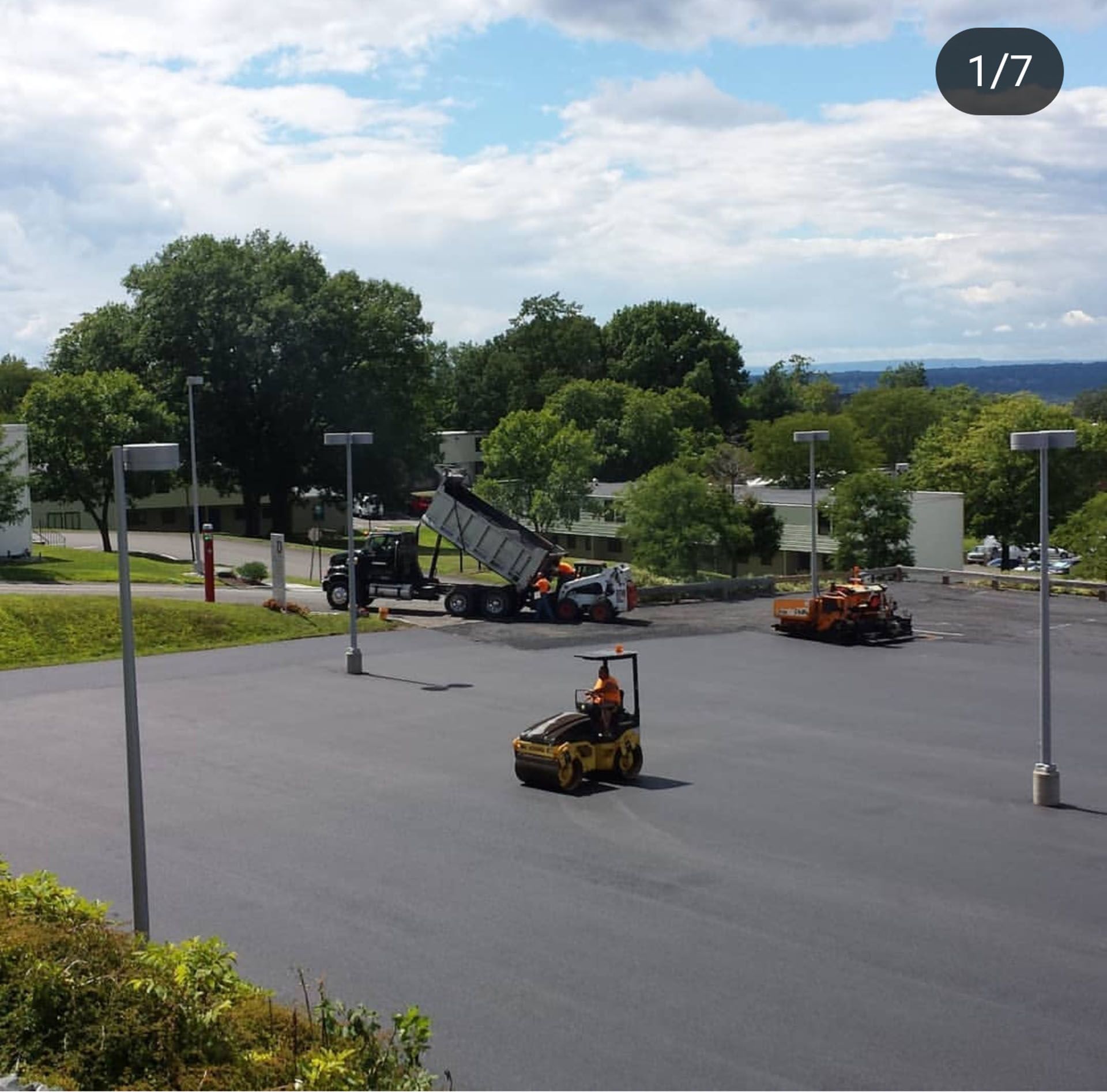a dump truck is being loaded with asphalt in a parking lot