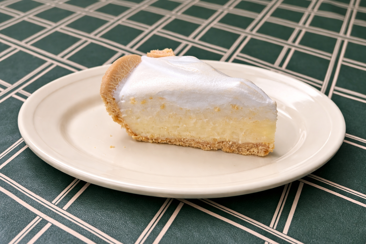 Cake with lattice pattern, dusted with powdered sugar, topped with cherries and mint on a white plate.