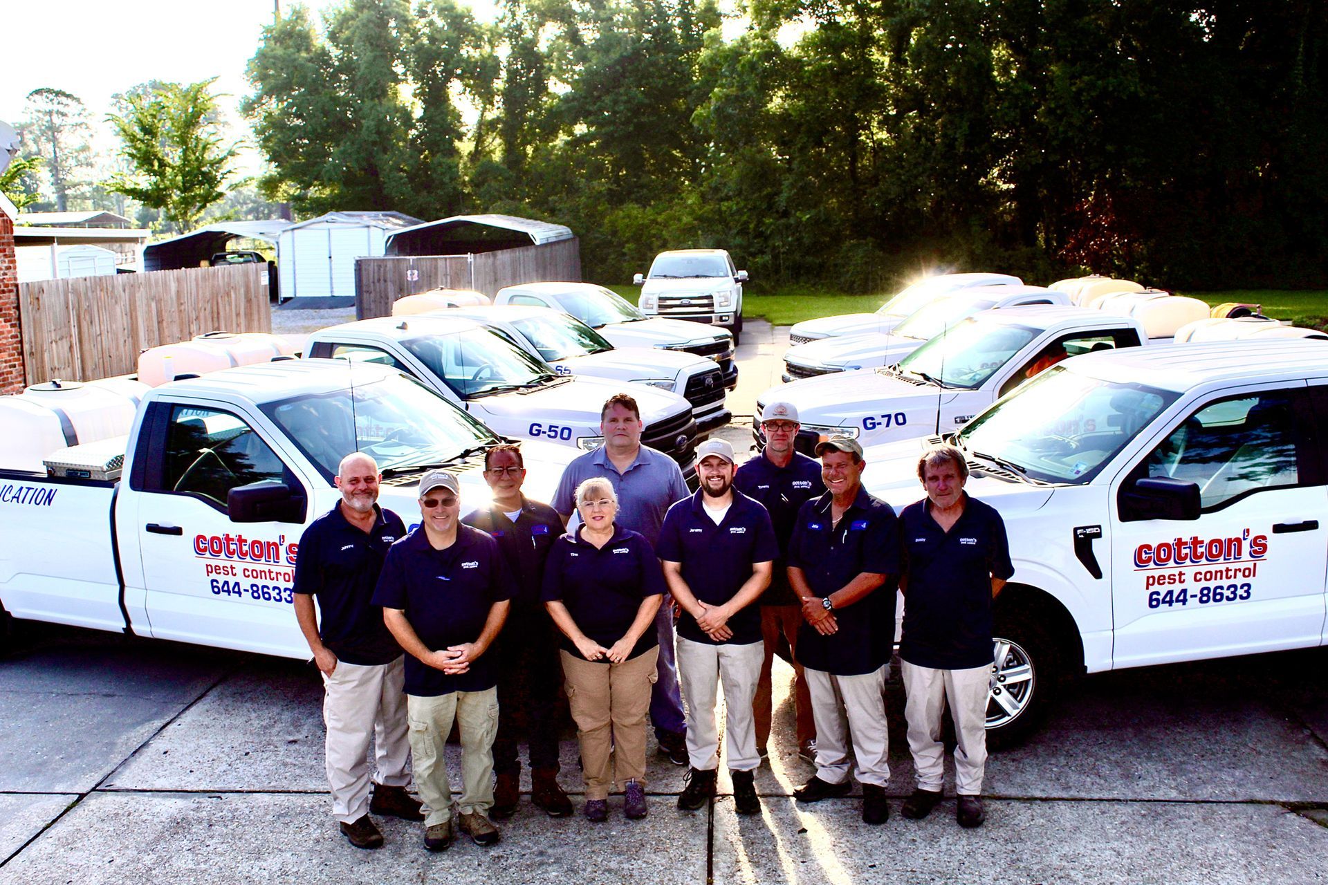 A group of people standing in front of a row of trucks that say contents