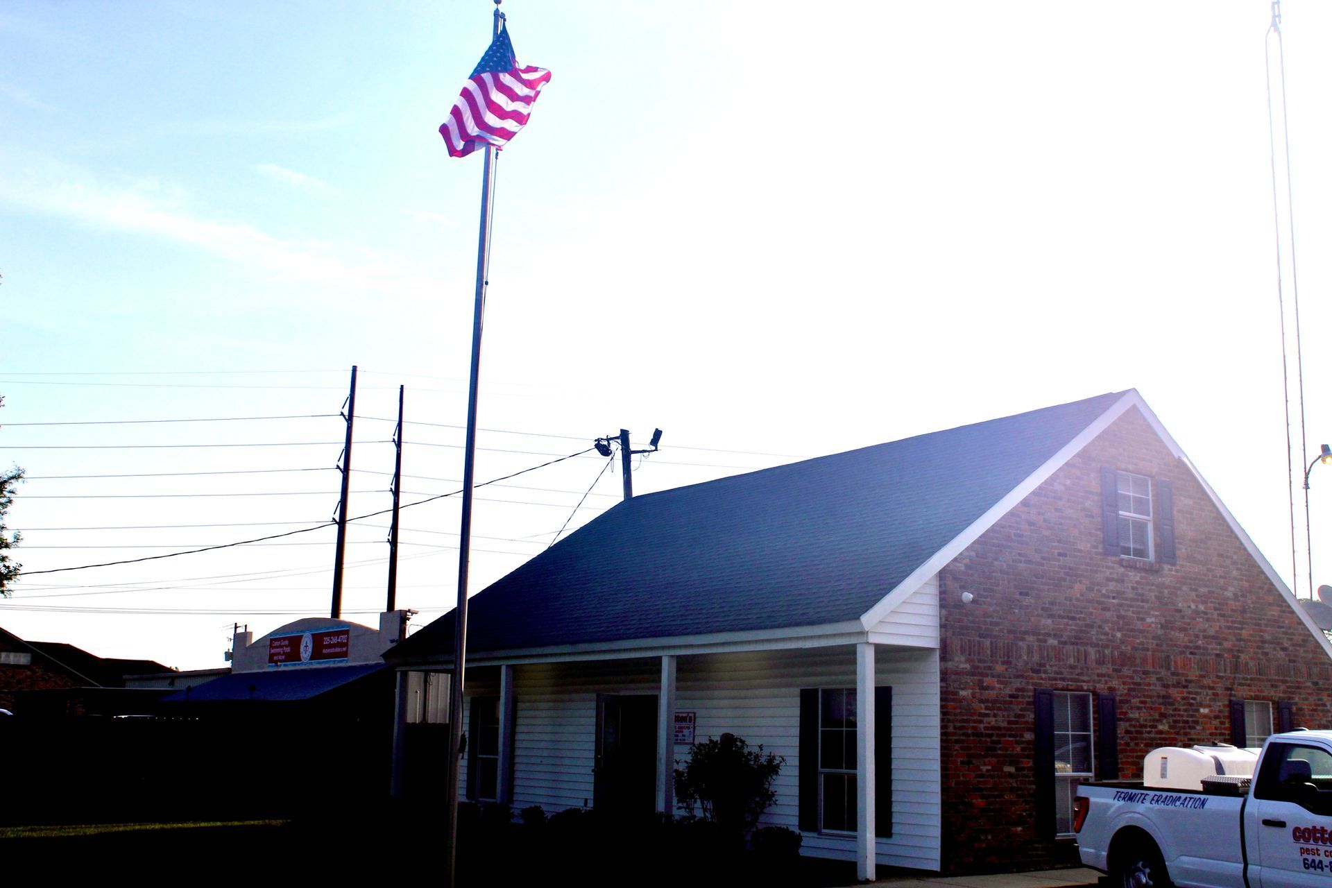 A white truck is parked in front of a brick building