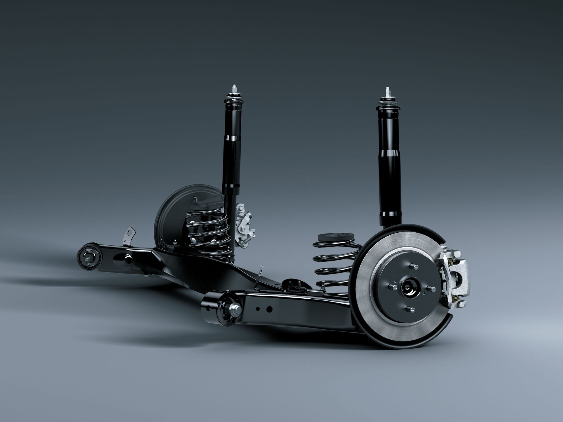 Automotive suspension components with wheel hub and shock absorbers on a gray background