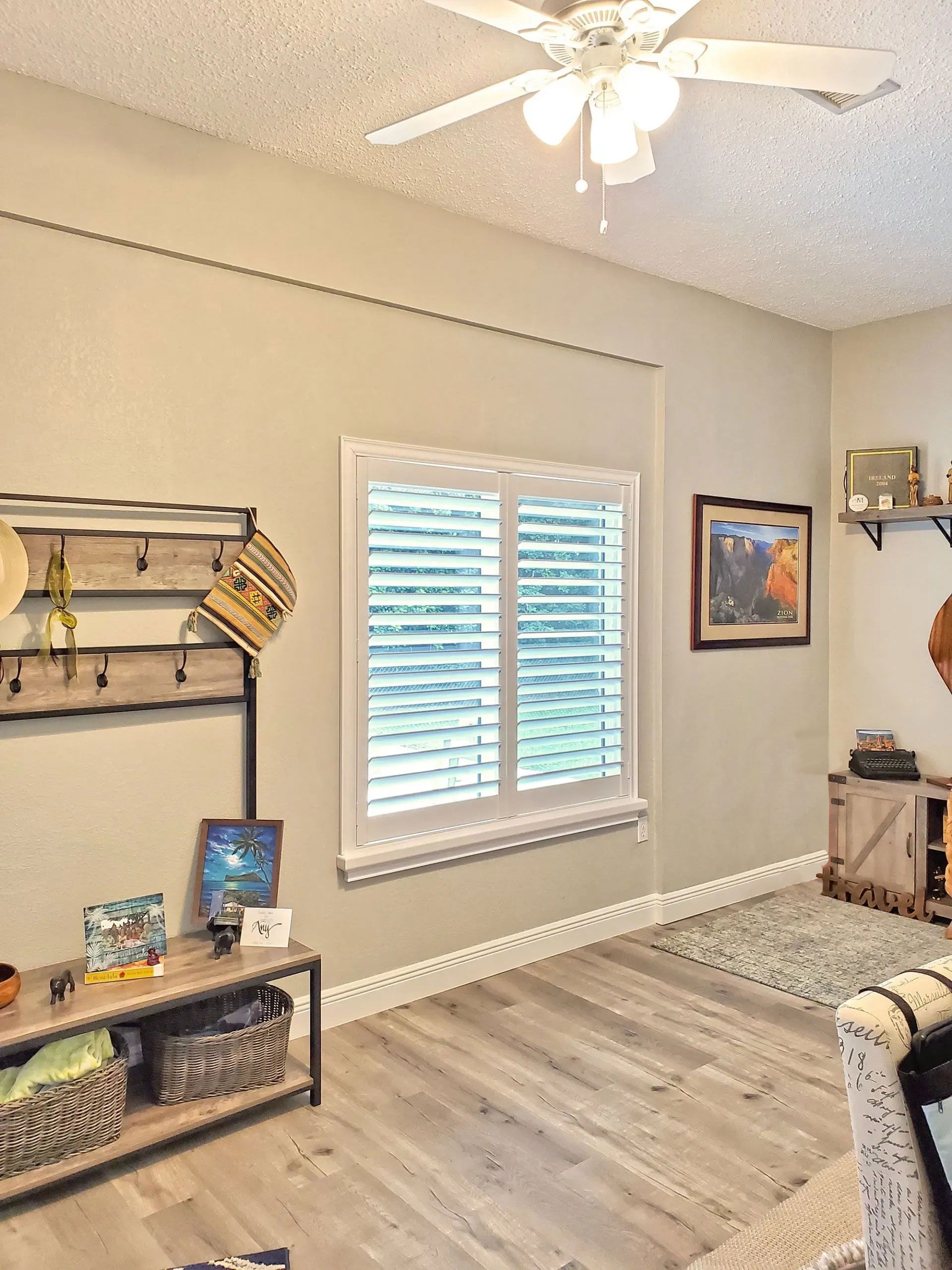 Interior room with tan walls, white shutters, and a rustic coat rack.