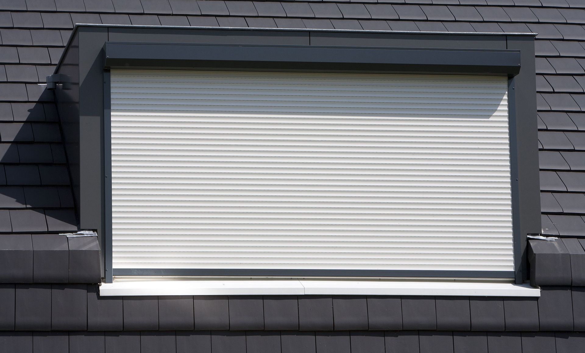 A window with a shutter on it is on a roof