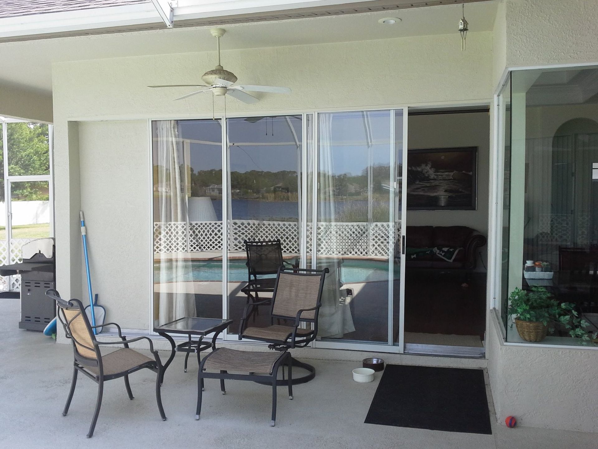 A patio with chairs and a table in front of a sliding glass door