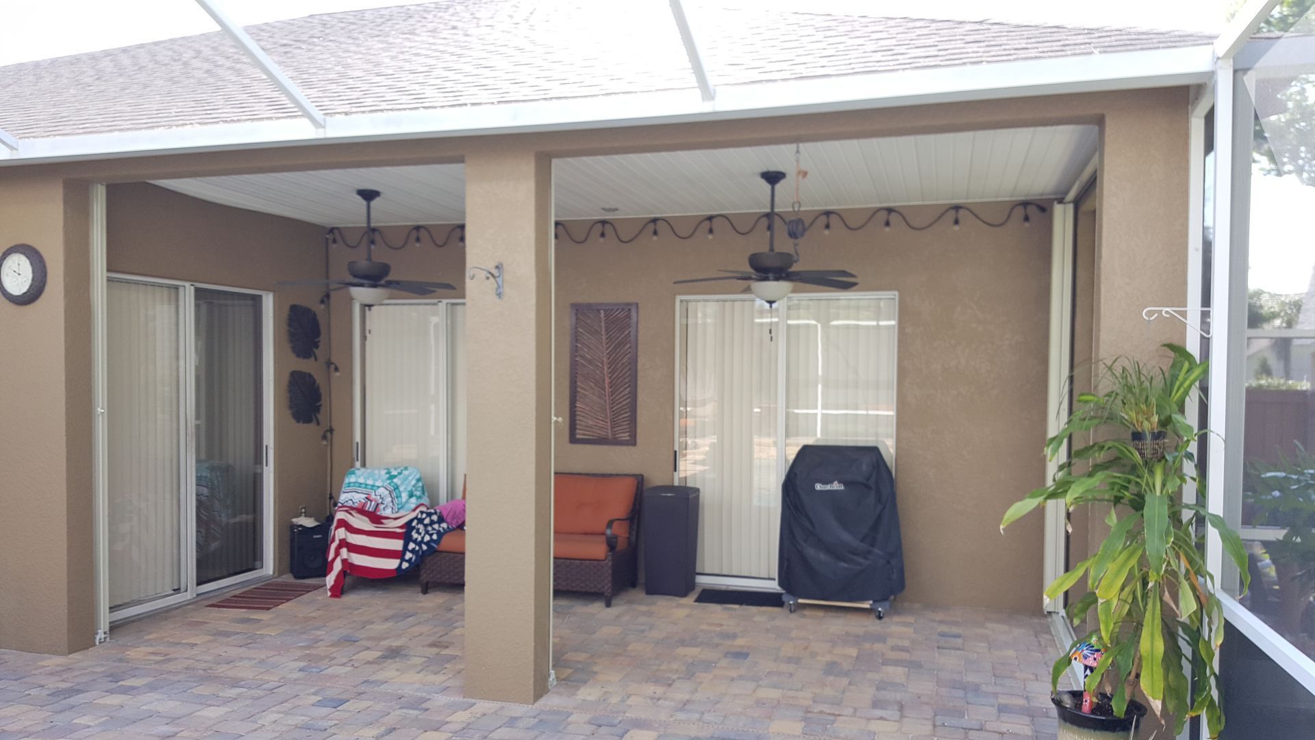 A patio with a ceiling fan and a grill