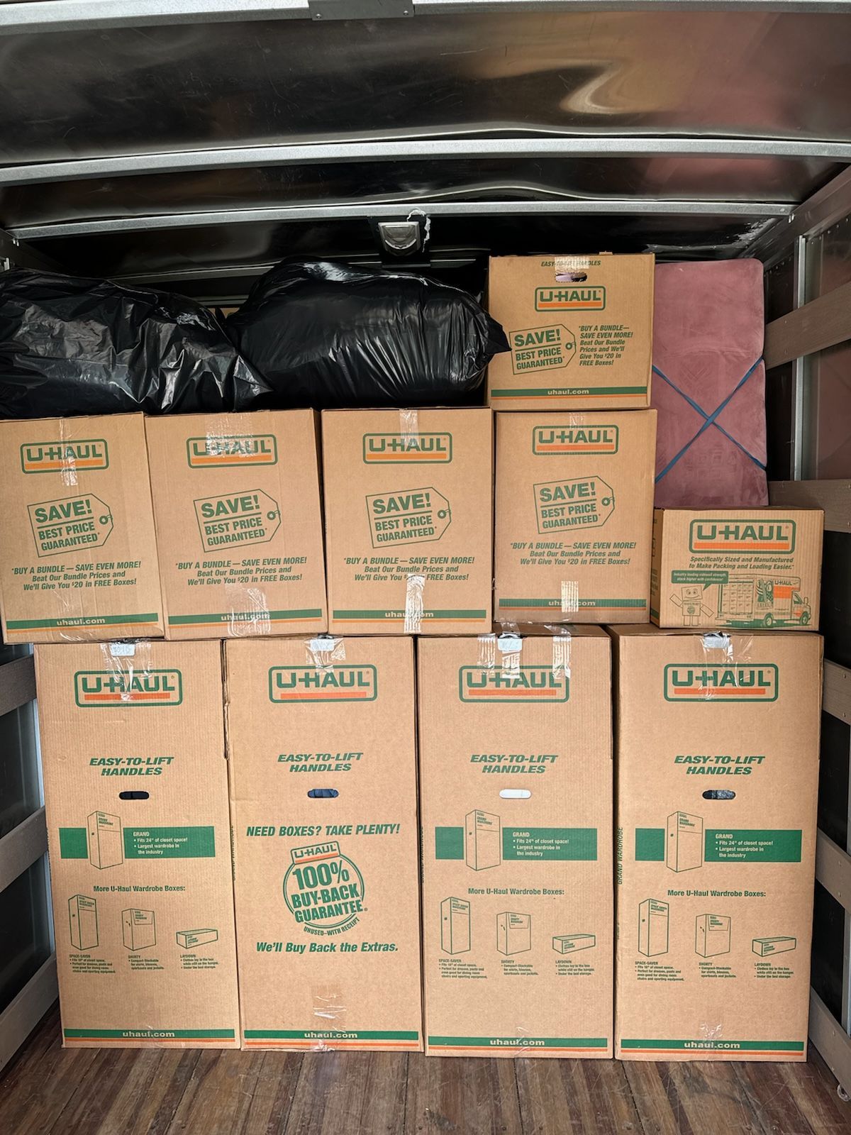 Stacked cardboard moving boxes packed in a truck or storage compartment