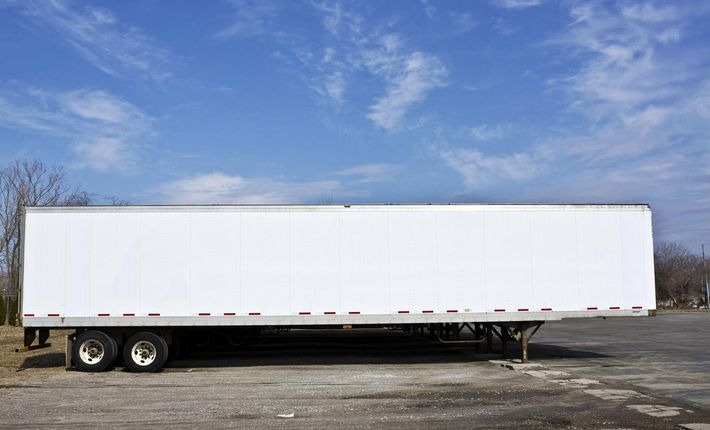 A white semi truck is parked in a parking lot.