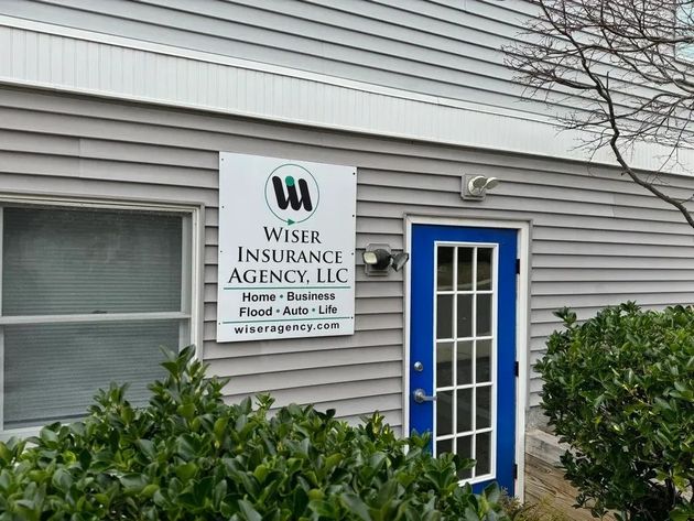 Wiser Insurance Agency sign beside a blue door on a gray-sided office building