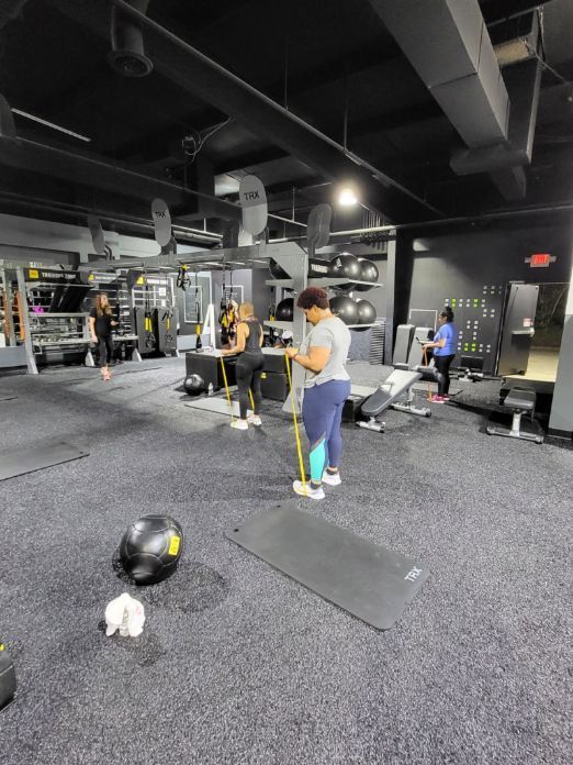 A group of people are standing in a gym.