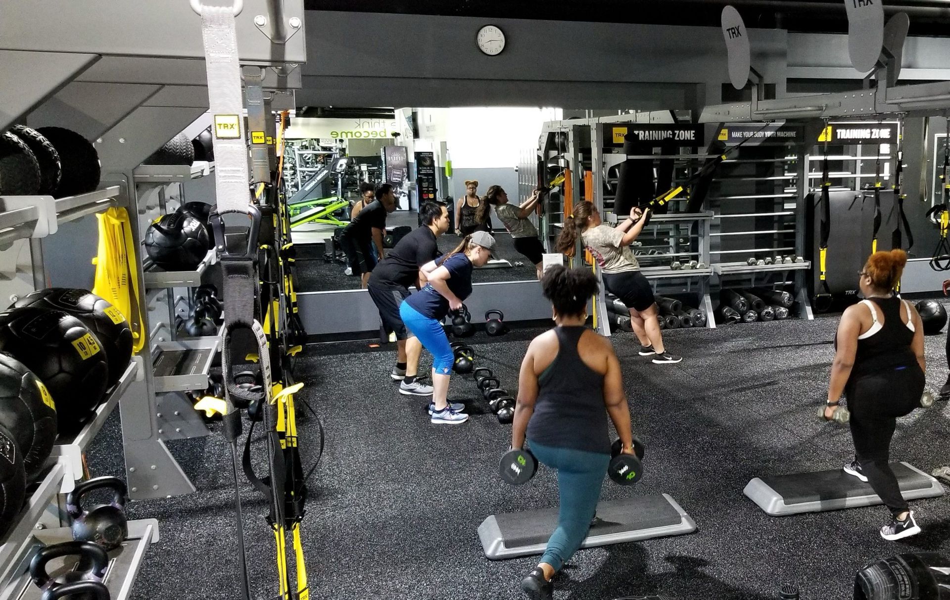 A group of people are doing exercises in a gym.