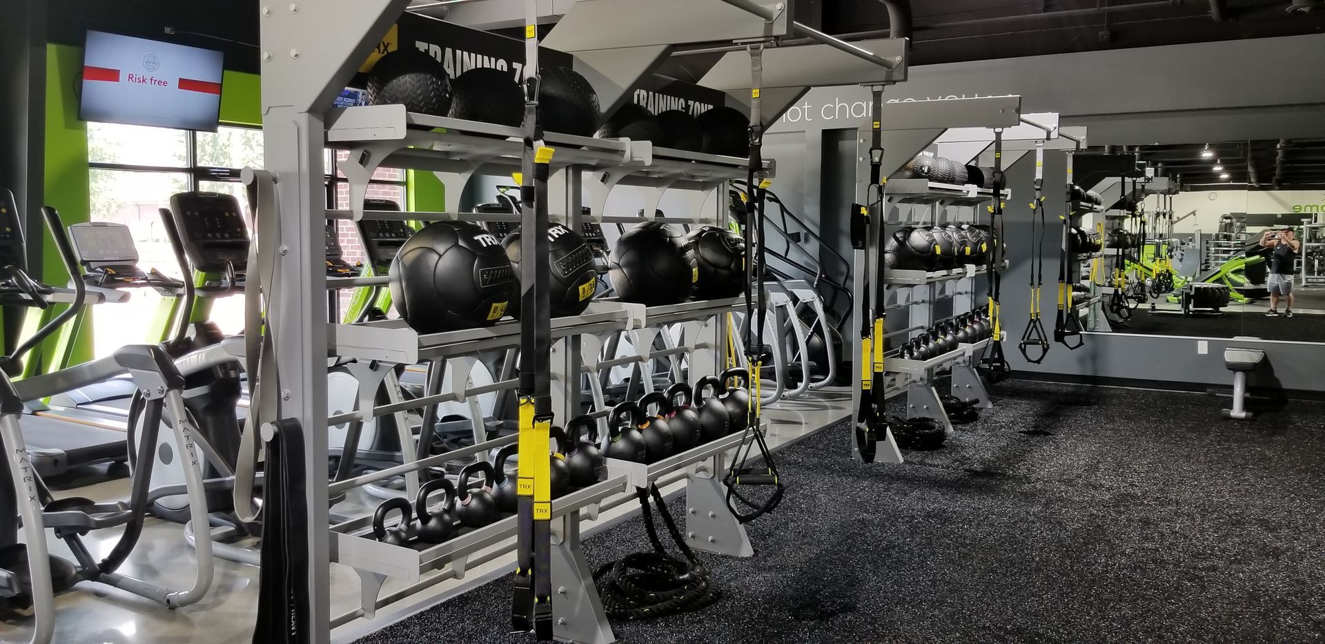 A gym filled with lots of exercise equipment and a large mirror.