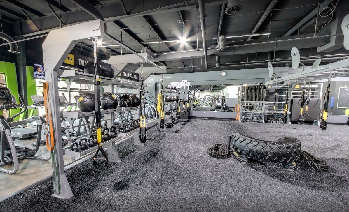 A gym with a lot of equipment and a tire on the floor.