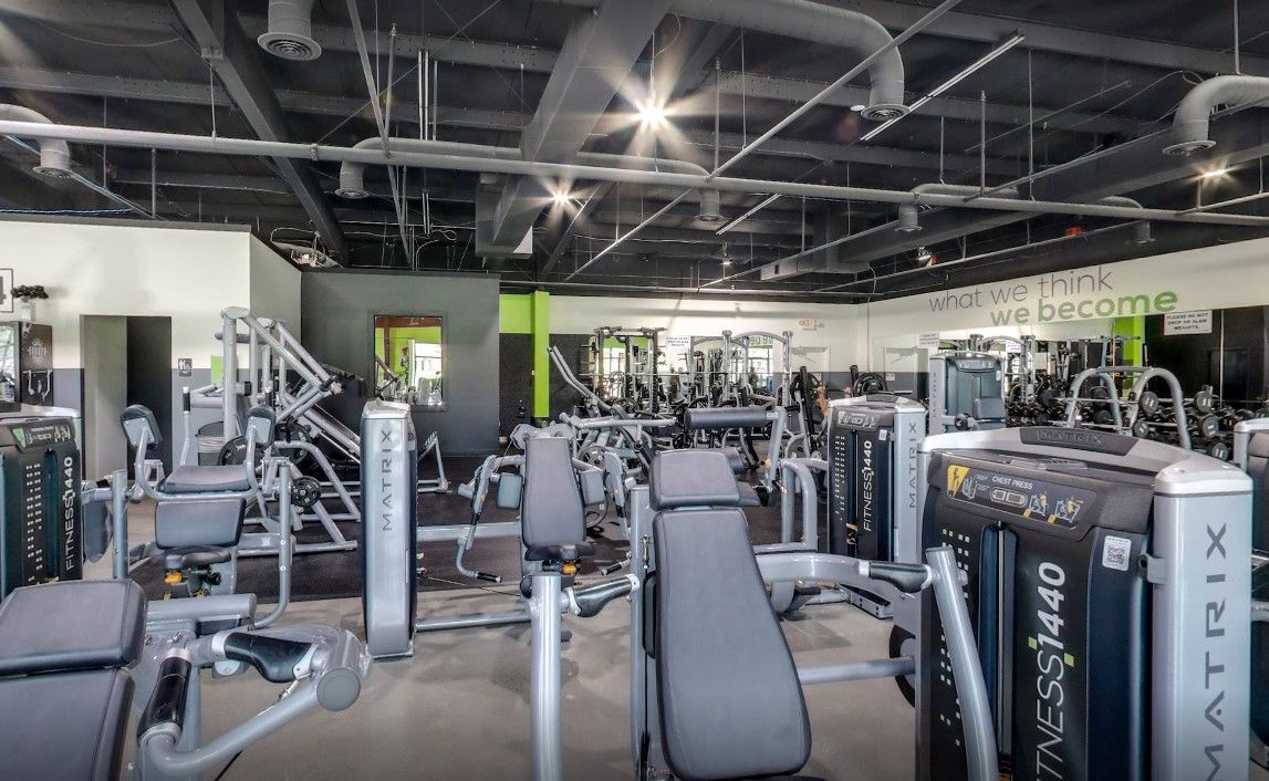 A large gym filled with lots of exercise equipment.