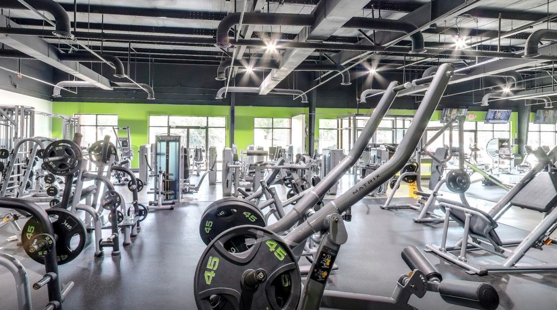 A large gym filled with lots of exercise equipment.