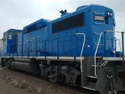 Blue locomotive numbered 2005 on railroad tracks, shown from the side.