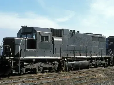 Black diesel locomotive on railroad tracks under a cloudy sky