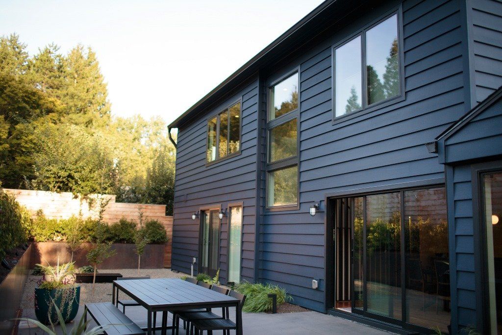 A large house with a table and benches in front of it.