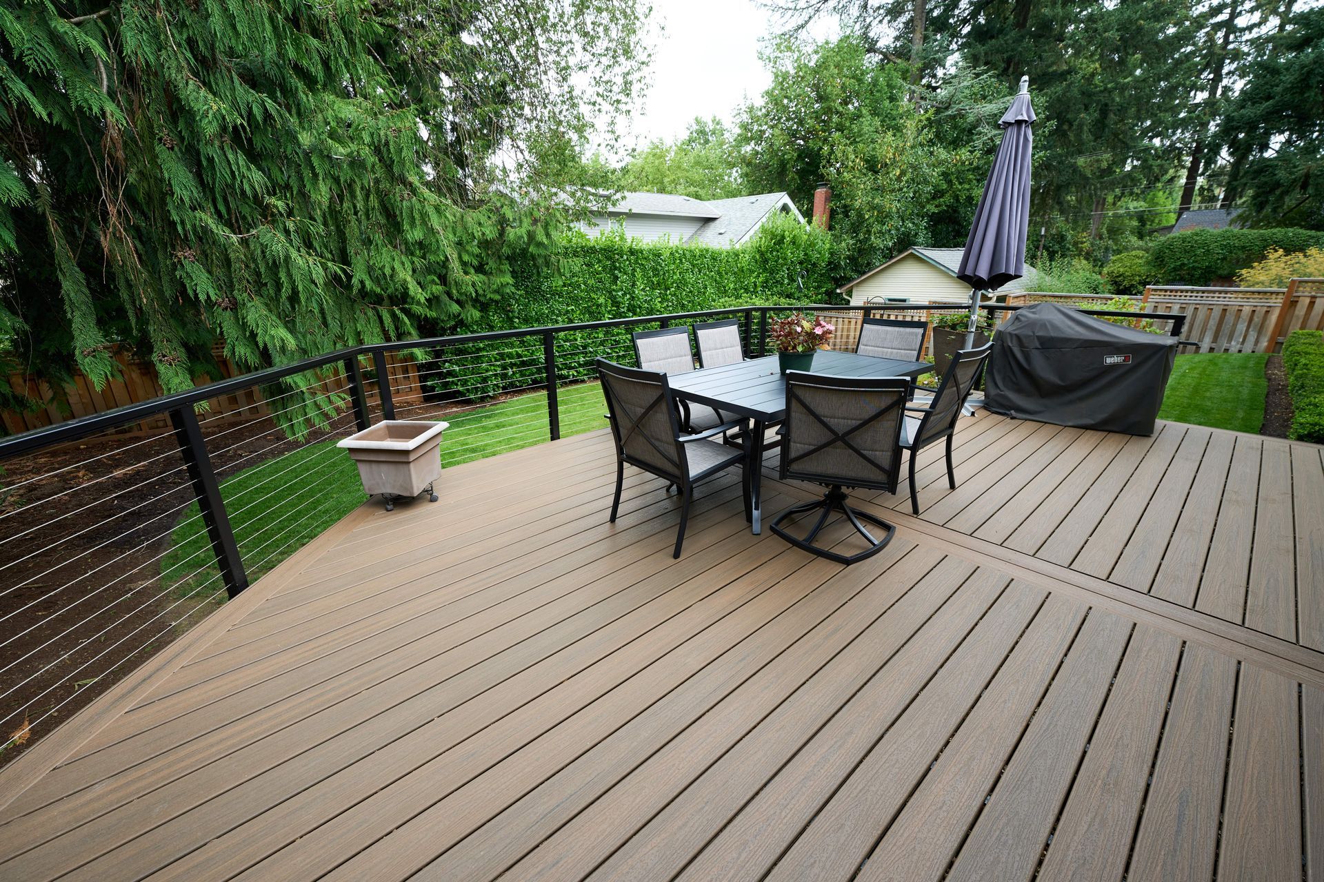 A spacious deck with a sturdy railing and a table, ideal for enjoying meals or leisure time outdoors.