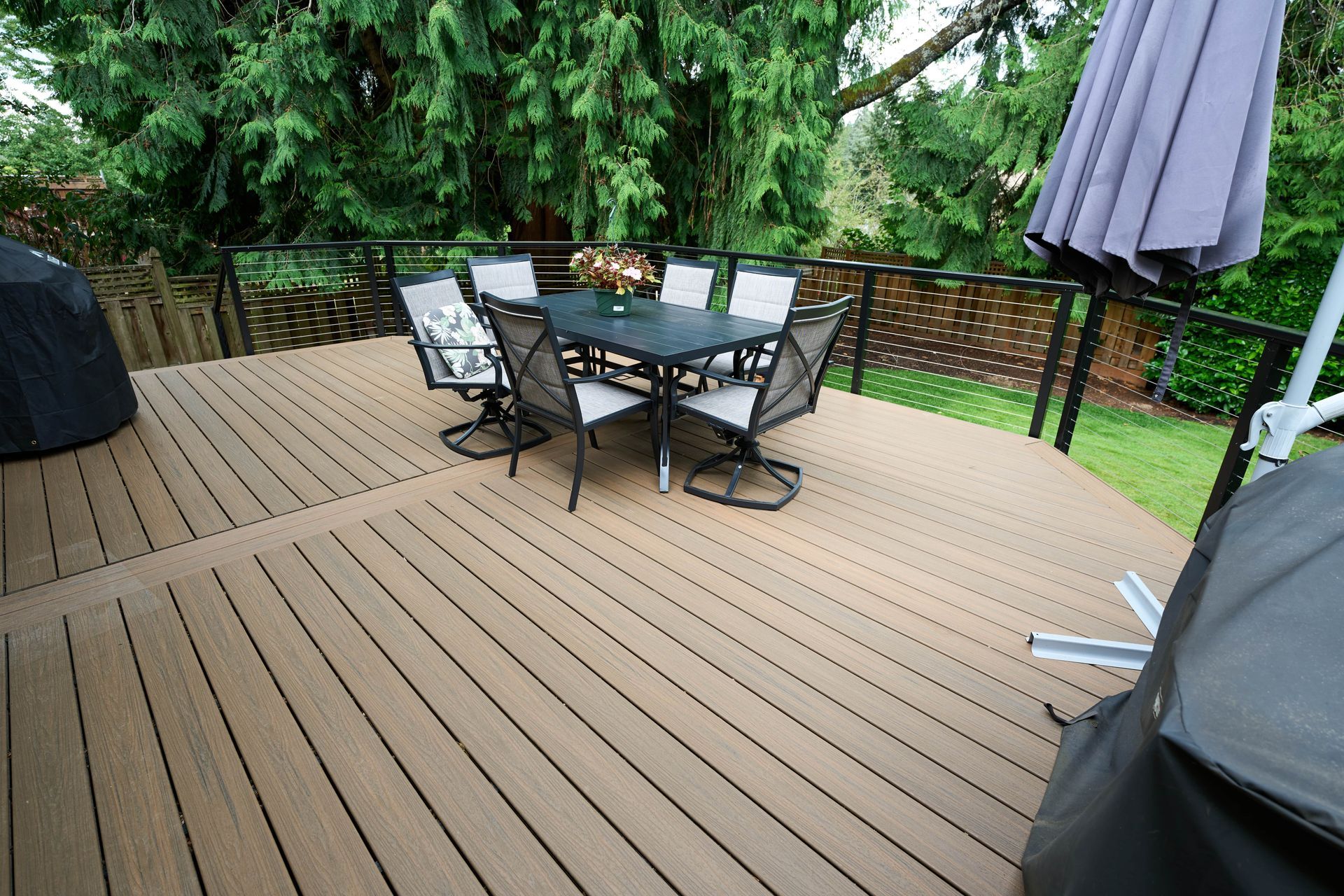 An inviting deck equipped with a railing and a table, perfect for outdoor dining and socializing.