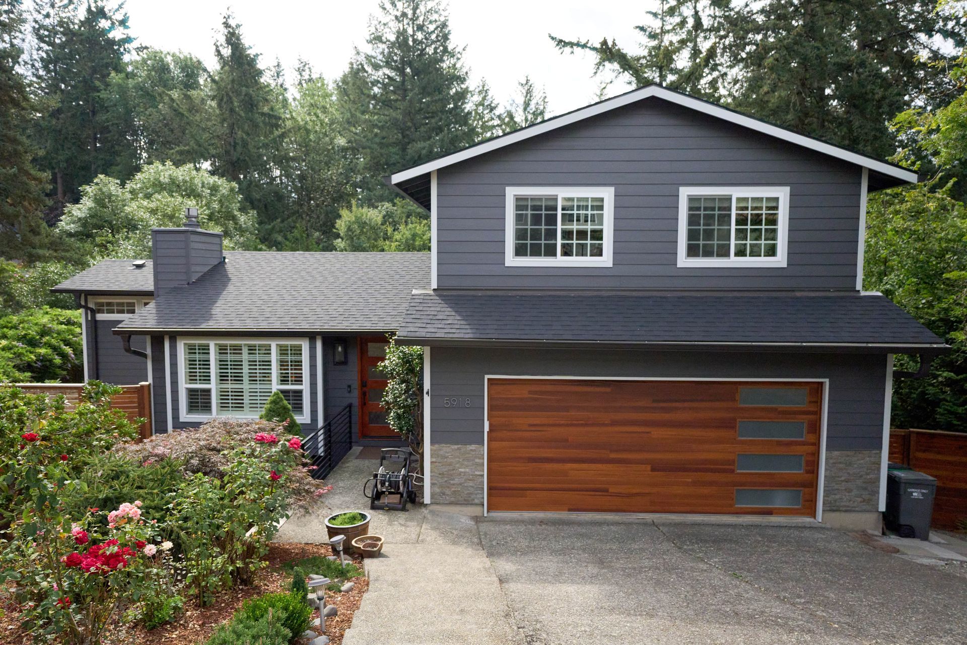 A gray house with a wooden garage door.