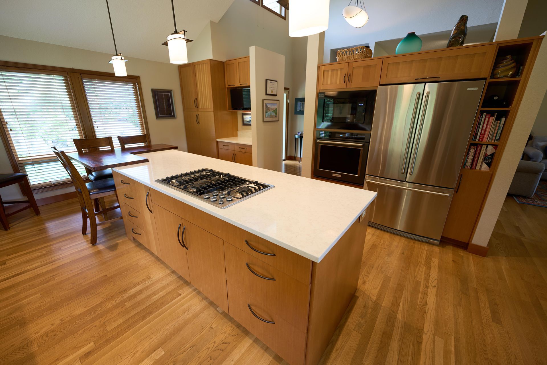 A modern kitchen featuring a central island and elegant wooden flooring, creating a warm and inviting atmosphere.