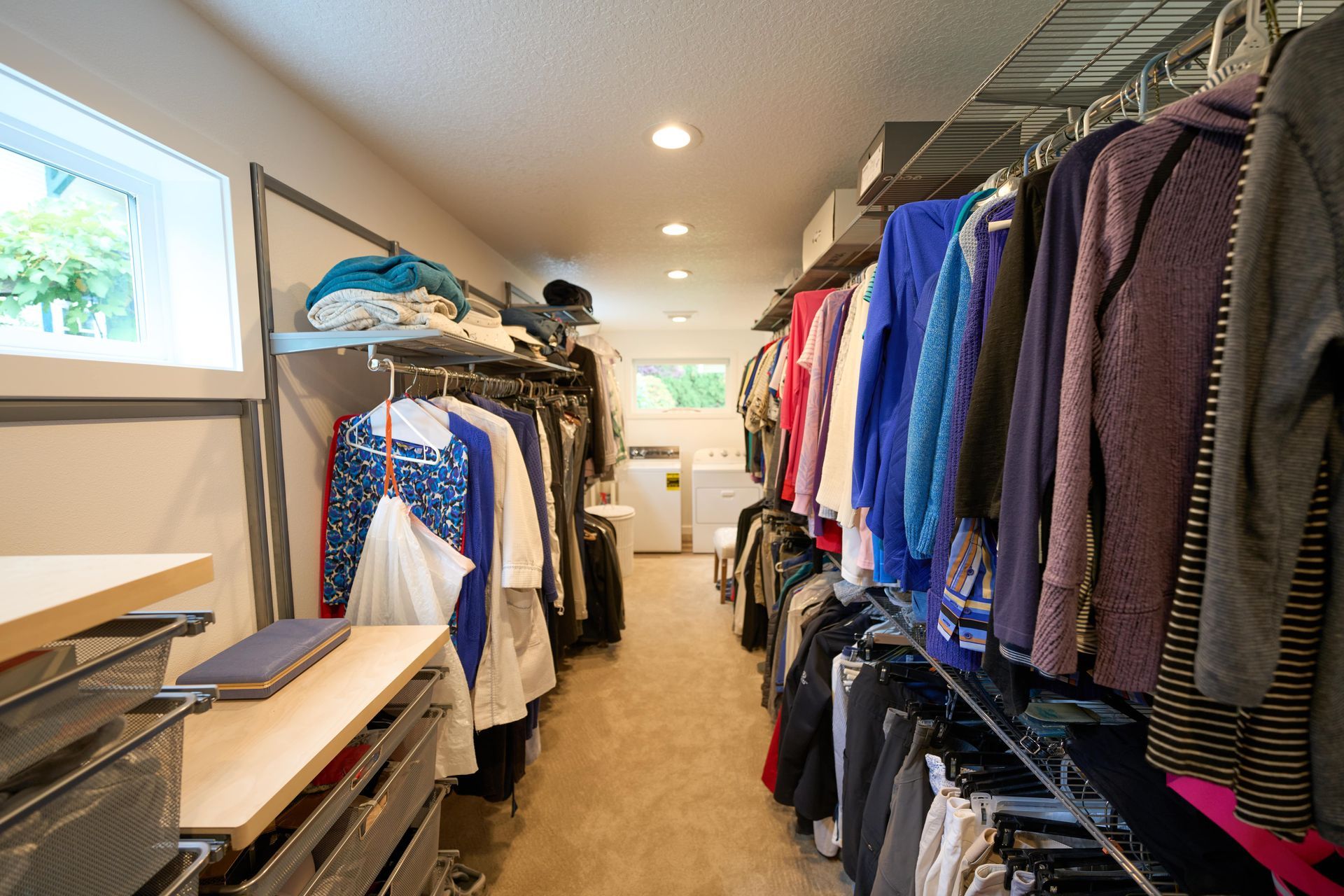 A neatly organized closet featuring a clothing rack filled with various garments, showcasing a range of colors and styles.