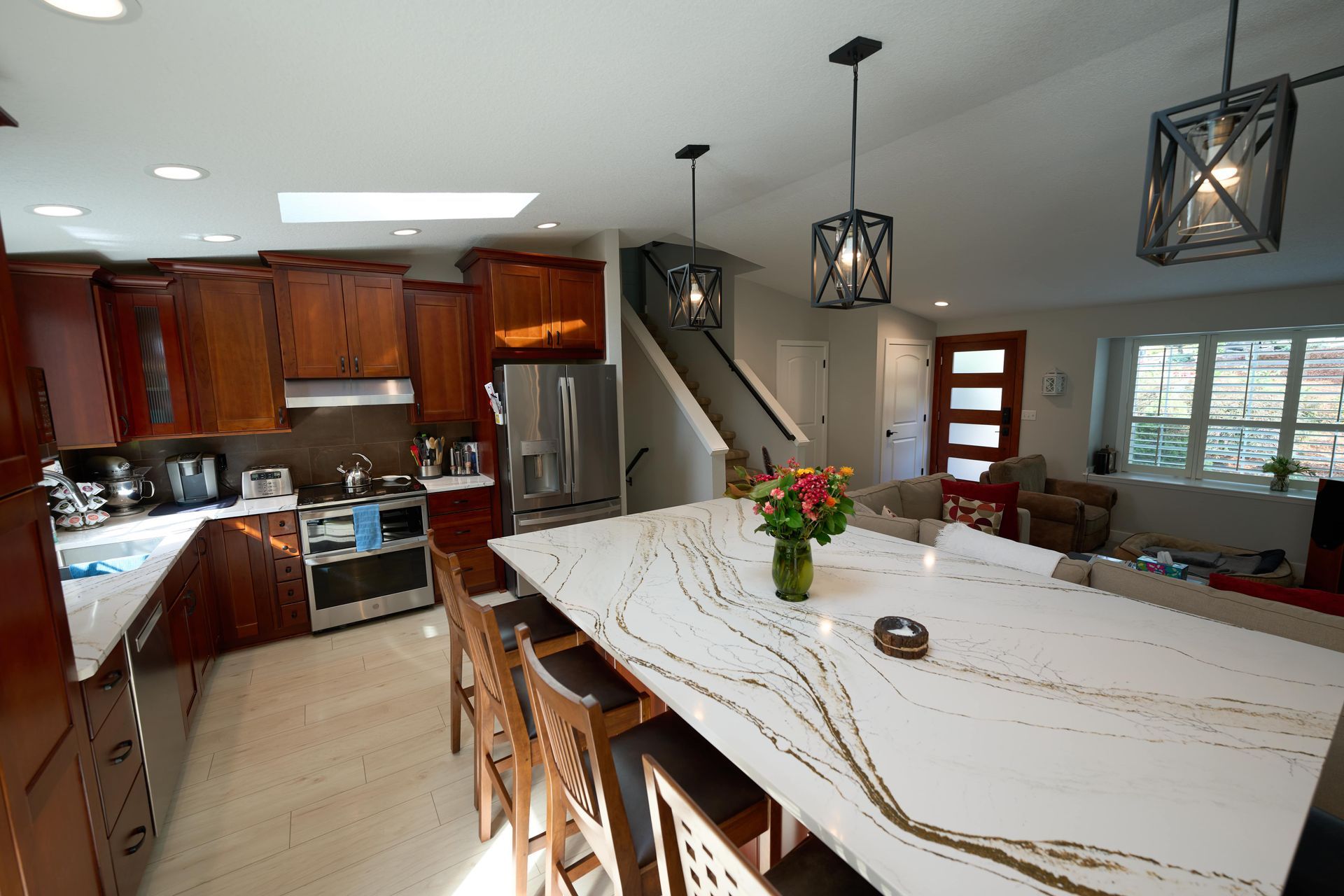 A spacious kitchen featuring a large island and a modern refrigerator, designed for functionality and style.