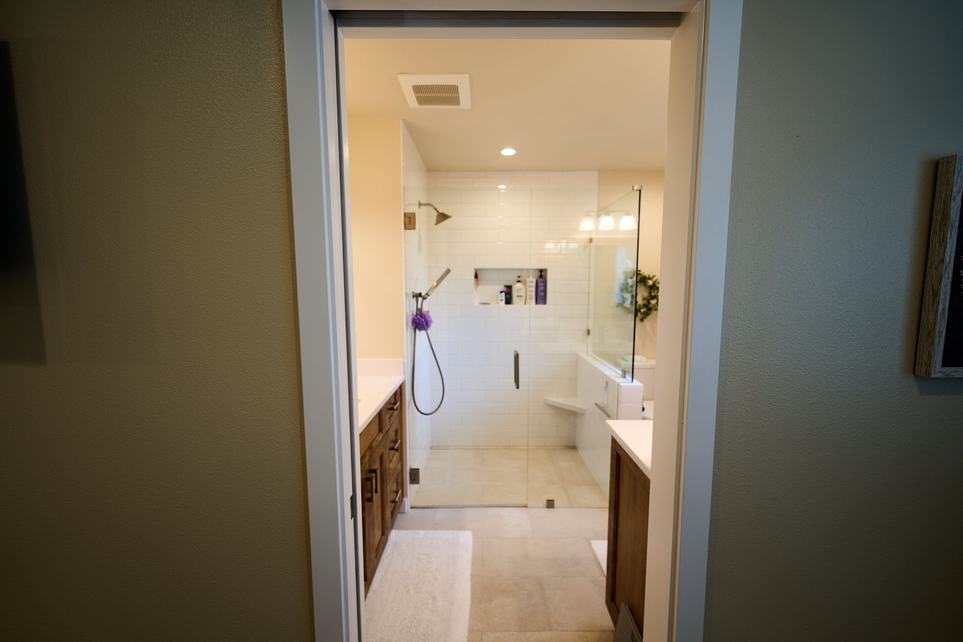 A bathroom with a walk in shower and a sink.
